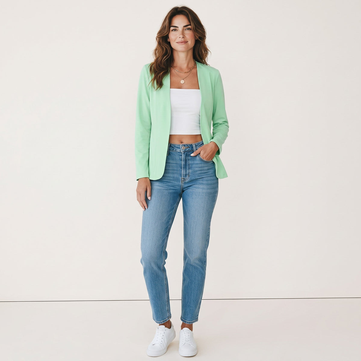 Model draagt een mintgroene Crisstians fashionstore kraagloze cardigan jas met een slim-fit pasvorm en jeans.