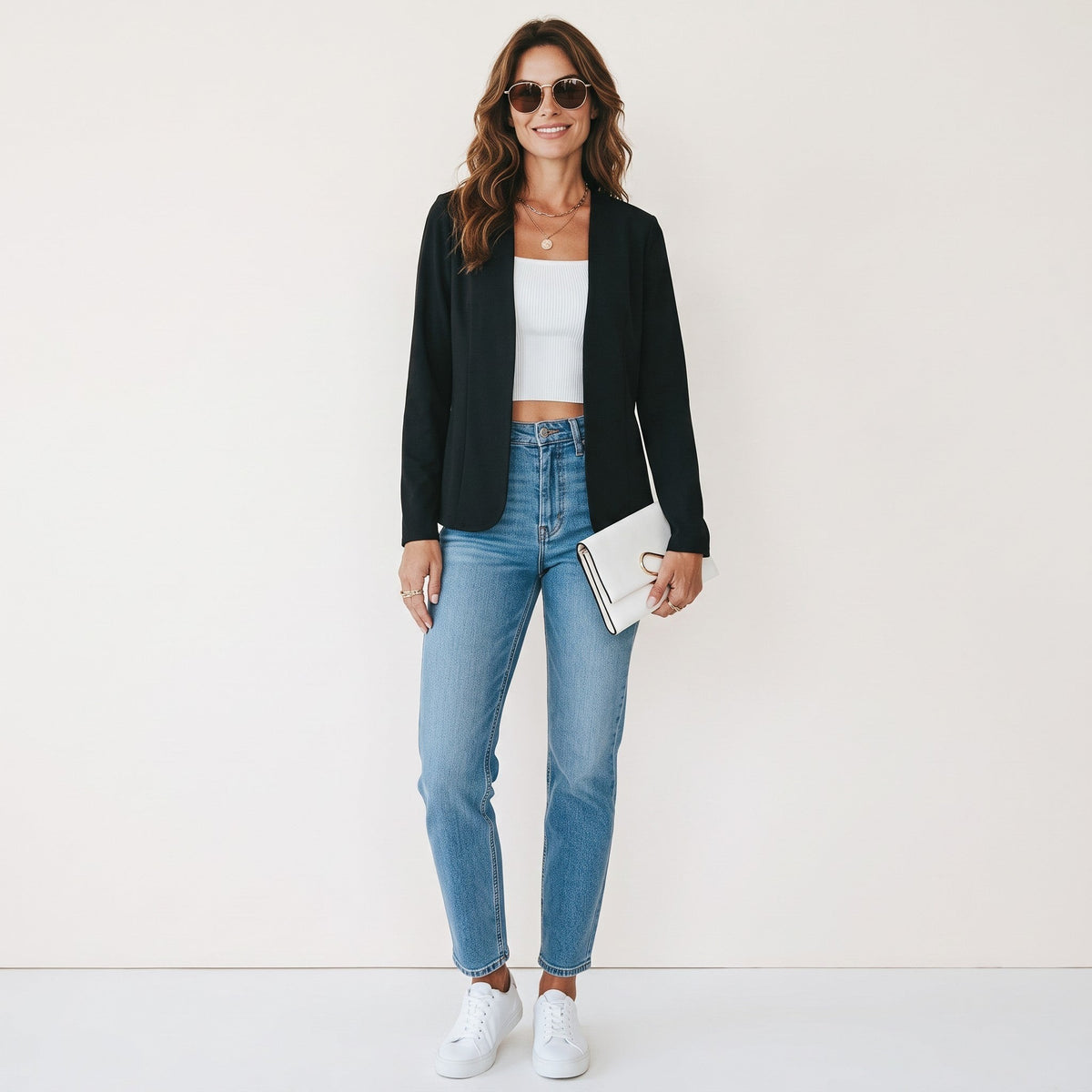 Crisstians fashionstore zwarte, kraagloze cardigan jas met slim-fit pasvorm gedragen door een vrouw met jeans en sneakers